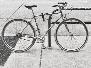 Fototapeta na wymiar Old Bicycle secured on a parking in a city gray background 