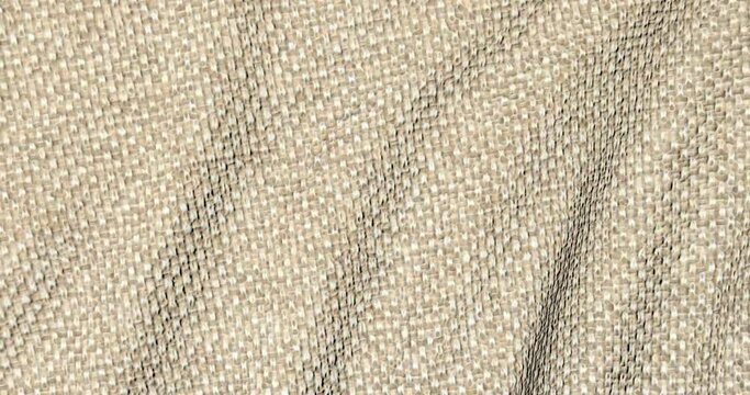 Beige woolen fabric in motion. The canvas is a background texture.