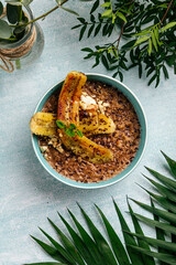 Bowl of chocolate oatmeal with caramelized banana and nuts