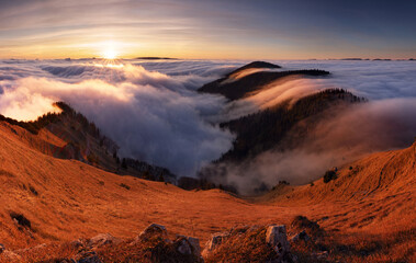 Colorfull sunset behind Mountain peak landscape above clouds - panorama