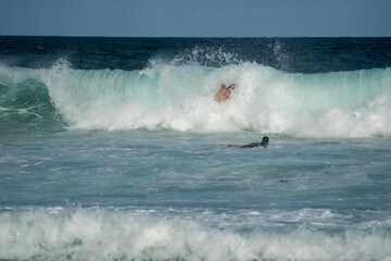 male surfer doing a turn on a wave at the beach in summer on a sunny day