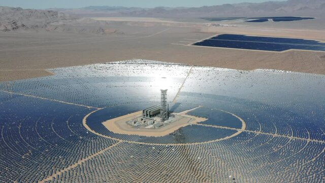 Modern solar power station with tower in aerial view, Concentrated solar power tower, solar farm center in Nipton California and Nevada desert boarder, USA. 4K aerial of sustainable energy generation