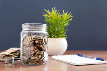 The coins are stored in a glass jar to accumulate finances.