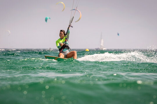 Smiling woman kitesurfing, Tarifa beach, Cadiz, Andalusia, Spain
