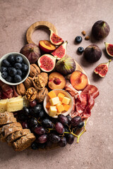 Planche de fruits, noix, fromage et jambon fumé