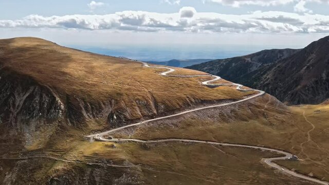 Aerial drone view of nature in Romania. Carpathian mountains, sparse vegetation, Transalpina road with cars