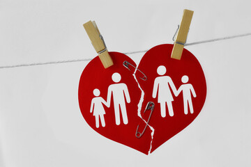 Broken heart with family joined with safety pin and attached on clothesline - Concept of saving marriage and family