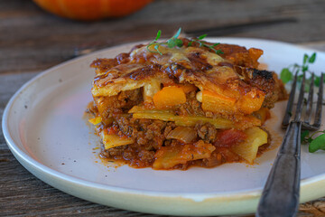 Ground beef casserole with pumpkin, vegetables and cheese on a plate