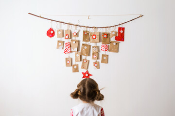 advent calendar hanging on wall. small surprises for kids. child looks at gifts