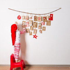 advent calendar hanging on wall. small surprises for kids. child looks at gifts