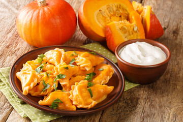 Traditional autumnal pumpkin dumplings close-up on a plate on the table. horizontal