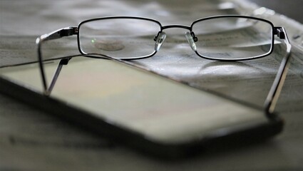 glasses composition with newsletters on dark background