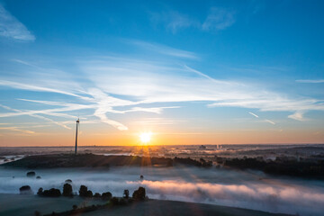 Fototapeta na wymiar Sunrise and the first rays of sunshine over the fog-covered Ruhr meadows in Duisburg, Germany