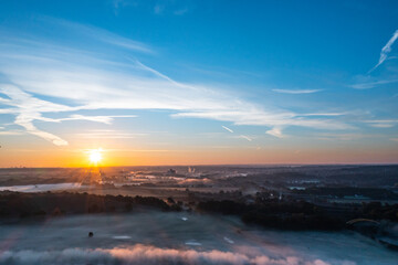 Sunrise and the first rays of sunshine over the fog-covered Ruhr meadows in Duisburg, Germany