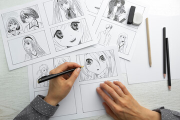 An artist draws a storyboard of an anime comics book. Manga style. - obrazy, fototapety, plakaty