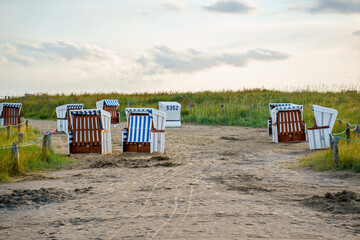 Traditional German roofed wicker beach chairs on the beach of North Sea, Nordsee, Germany,...