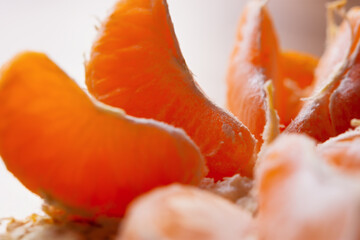 Mandarin macro background. Orange slices are sweet appetizing close-up in natural light. Selective focus, rear view blur. Conceptual festive winter background, New Year. Tropical juicy fragrant fruit