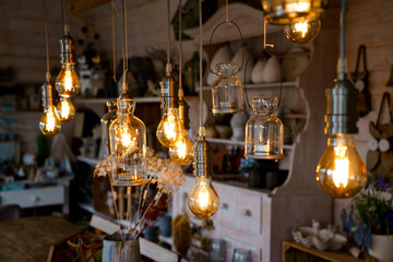 Beautiful arrangement of wooden decor and ceramic decoration in a shop for indoor, outdoor and garden. Light bulb as fairy lights.