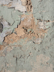 Old textured piece of a turquoise, beige, gray street wall in the morning light, background