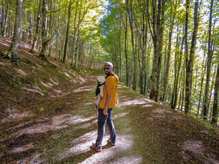 Obraz premium Irati forest or jungle in autumn, a young hiker at sunset on a path of pine trees. Ochagavia, northern Navarra in Spain