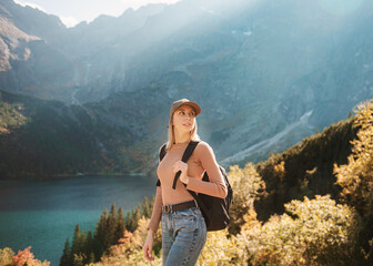 Naklejka premium Wanderlust and travel concept. Stylish traveler girl in hat looking at map, exploring woods.