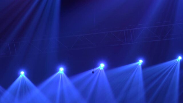 Animation of stage lights frame. Bright shiny stage lights flashing movement entertainment spotlight projectors in the dark, blue soft light spotlight strike on black background.