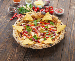 Tradition homemade spicy mexican pizza with chili, beef, onion, jalapeno pepper and ingredients top view on wooden table. Cooking at home concept