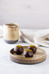 Orange and turmeric chocolate truffles in a plate. Sugar, gluten and lactose free, vegan.