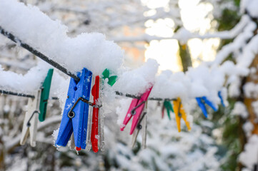 Plastic clothespins on a clothesline in frosty winter weather after a snowfall.