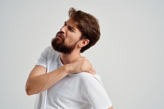 emotional man in a white t-shirt stress medicine pain in the neck studio treatment