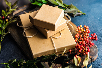 Christmas gift boxes surrounded by pinecones, holly and fresh berries