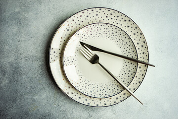 Two porcelain Christmas plates with snowflake borders and cutlery