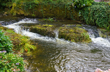 a stream running through estate gardens of the beautiful grade I listed gardens at Bodnant Gardens, Colwyn Bay, Wales UK