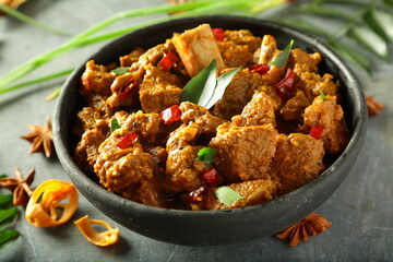 Spicy beef roast with exotic Indian spices, traditional recipes background.