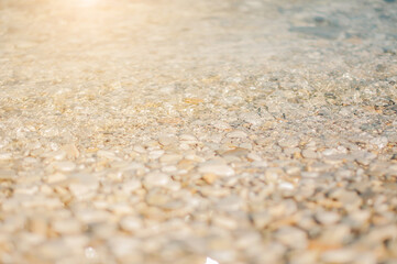 Fototapeta na wymiar Sea pebble gravel beach, transparent sea. View from the top. Selective focus, toned colores.