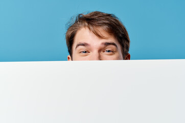 Cheerful man with white mockup poster sign copy-space close-up