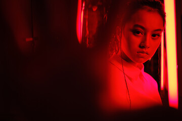 Teenage asian girl in red neon light
