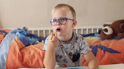 Funny happy baby with a fork eating food