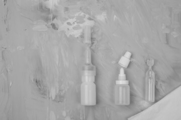 Different types of medical drops, nasal spray on grey stone background. Sanitation of the nose, rinsing. Viruses. Diseases. Mockup