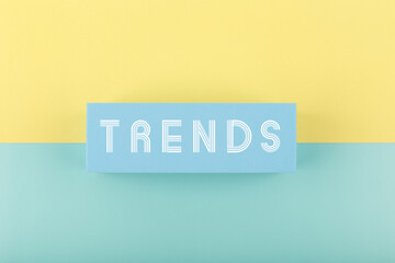 Trends written on rectangle on light multicolored yellow and aqua blue background