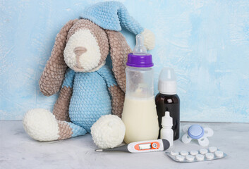 Breastfeeding and pills .Medication and lactation. Milk, children's toy, thermometer, syrop, pills and pacifier on blue background. Viruses. Copyspace