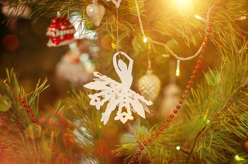 White ballet dancer origami toy for christmas decoration haning on a Christmas tree.