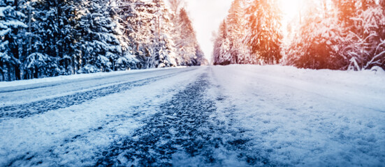 Closeup view of the beautiful country road in winter forest.
