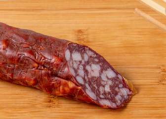 The cut off Brunswick sausage lies on a cutting board.