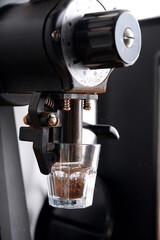 Grinding coffee beans in a cup with machine