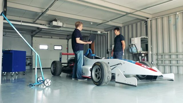 Racing car is getting checked by garage specialists