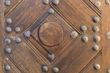 Old wooden doors, elements connected with metal rivets, close-up, wood texture