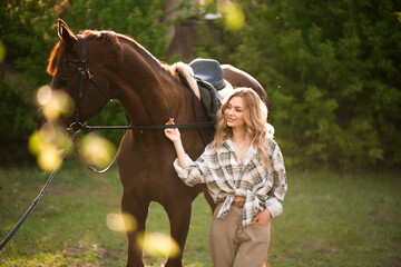 Obraz premium Beautiful girl with her horse and beautiful warm sunset in the spring forest.