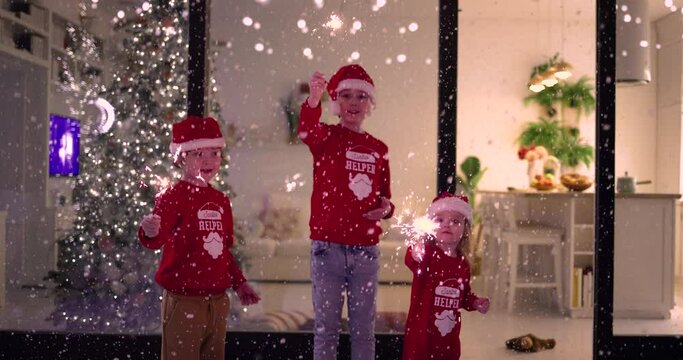 happy family celebrating nye, lighting sparklers at the patio at home, having fun on Christmas under the snowfall