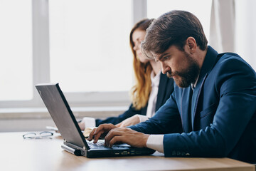 managers sitting at a desk with a laptop communication finance professionals